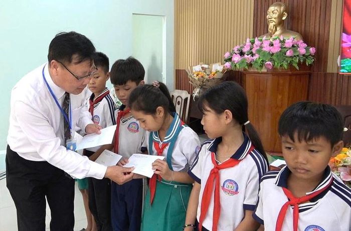 Phó Chủ tịch Hội Khuyến học tỉnh Lâm Đồng Đỗ Hoàng Tuấn trao học bổng cho các em học sinh xã Vĩnh Hảo. Ảnh: Hội Khuyến học tỉnh Lâm Đồng