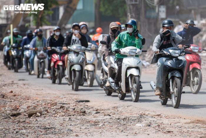 Nhiều người đi xe máy phải dùng khẩu trang, áo chống nắng che kín mặt khi đi qua khu vực công trường. 