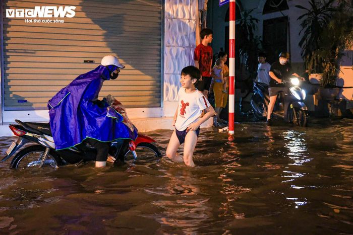 Một số người tranh thủ đứng trú dưới mái hiên chờ nước rút rồi mới tiếp tục về nhà.