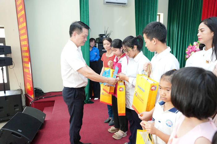 Phó Chủ tịch UBND xã Phù Đổng Nguyễn Đình Quang trao tặng quà cho các em học sinh trên địa bàn. Ảnh: Nguyễn Sơn