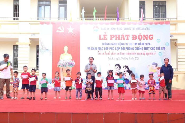 Lãnh đạo địa phương trao quà cho các em nhỏ.