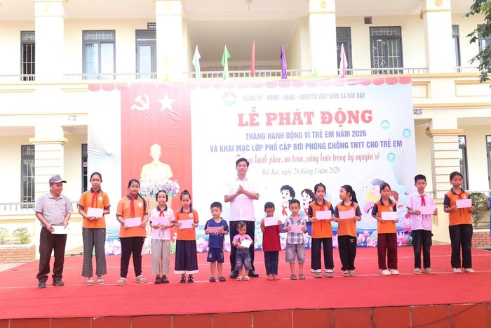 Lãnh đạo địa phương trao quà cho các em nhỏ.