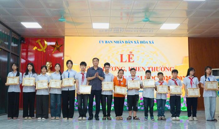 Lãnh đạo xã Hòa Xá trao giấy khen cho học sinh tiêu biểu. Ảnh: Huy Nguyện