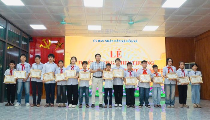 Lãnh đạo xã Hòa Xá trao giấy khen cho học sinh tiêu biểu. Ảnh: Huy Nguyện