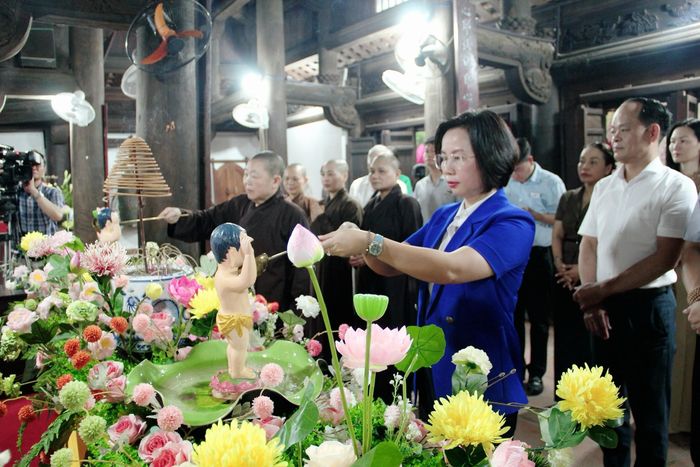 Chủ tịch Ủy ban MTTQ Việt Nam thành phố Bùi Huyền Mai cùng các đại biểu thực hiện nghi thức tắm Phật. Ảnh: Lê Phương