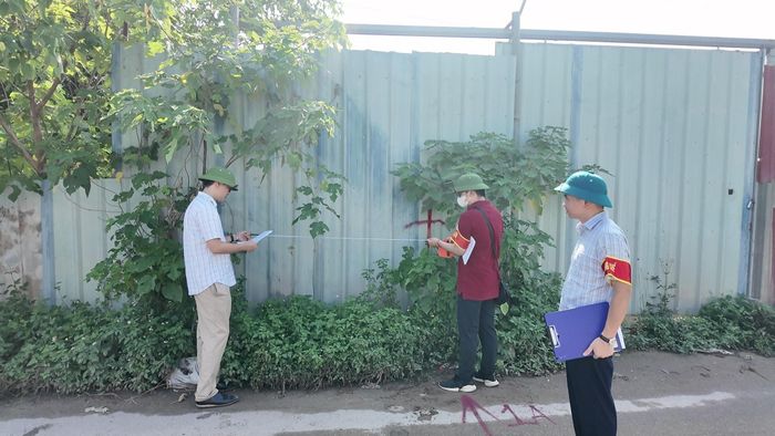 Lực lượng chức năng đo đạc hiện trạng trước khi thực hiện cưỡng chế kiểm đếm bắt buộc. Ảnh: AK