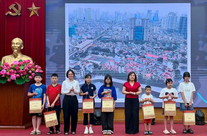 Lãnh đạo phường Ô Chợ Dừa trao quà cho thiếu nhi có hoàn cảnh khó khăn. Ảnh: Võ Giang