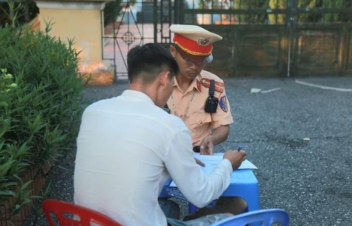 Tài xế ô tô tải có gắn tên "DN Quang Tuấn" bị lập biên bản xử lý vi phạm - (ảnh Nhật Tân).