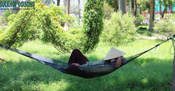 Một lao động tự do tranh thủ chợp mắt dưới bóng cây sau nhiều giờ làm việc ngoài trời nắng nóng. Ảnh: H.H