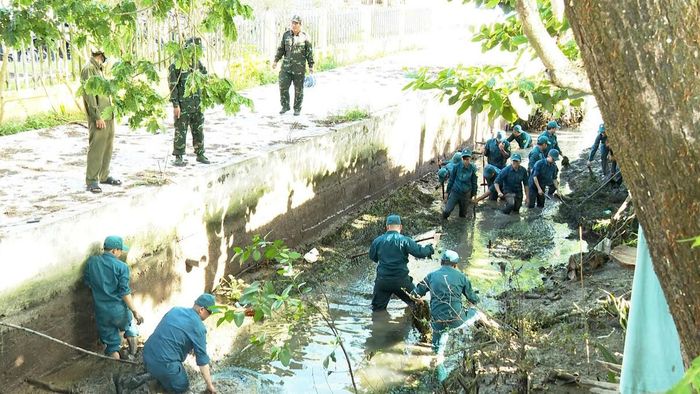 Từng gàu bùn được vét lên, dòng kênh dần thông thoáng hơn qua sự chung sức của cán bộ, chiến sĩ dân quân trong công trình dân vận vì cộng đồng. Ảnh Trung Ngãi