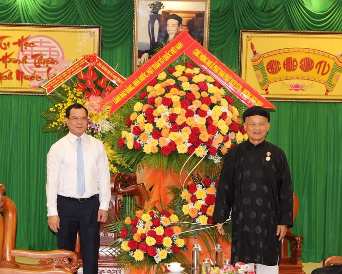 Ông Nguyễn Đình Khang tặng lẵng hoa chúc mừng Phó Huấn sư Nguyễn Ngọc Ánh. Ảnh: QĐ. 