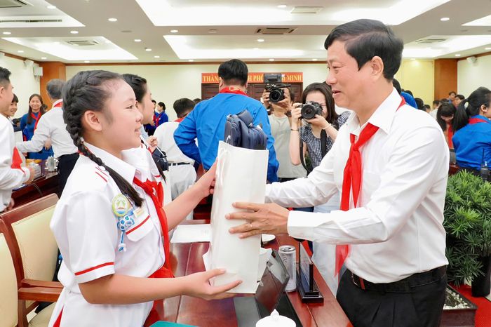  Ông Võ Văn Minh, Ủy viên Trung ương Đảng, Chủ tịch HĐND TP.HCM, tặng quà cho các em học sinh tại buổi gặp gỡ. Ảnh: HOÀNG HÙNG 