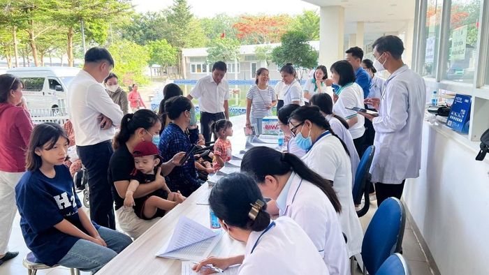 Nhân viên y tế tiếp đón, hướng dẫn và hỗ trợ làm thủ tục khám cho trẻ.