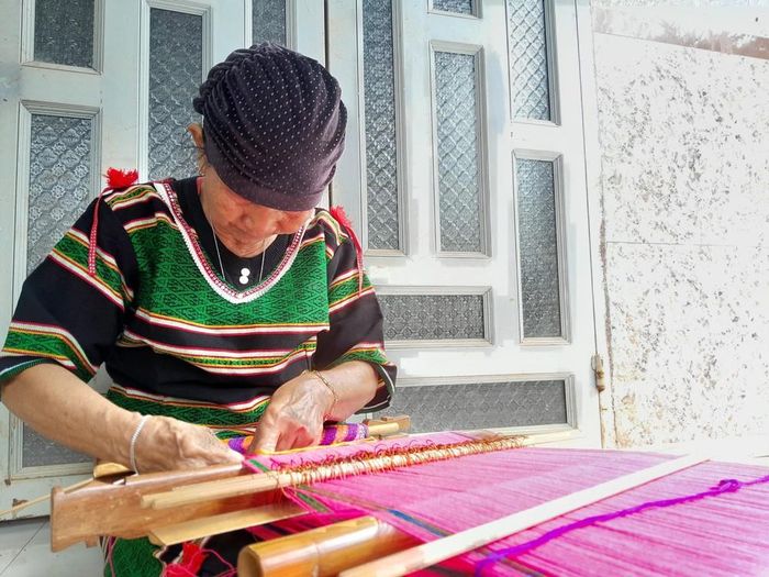 Bà Thị Y Rơ tỉ mỉ từng đường chỉ để tạo tấm thổ cẩm chất lượng. Ảnh: K GƯỈH-TTXVN