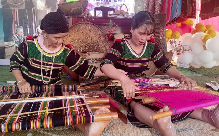 Bà Thị Y Rơ (76 tuổi, người dân tộc M’nông) truyền dạy nghề dệt thổ cẩm cho con dâu là chị Thị Tức. Ảnh: K GƯỈH-TTXVN
