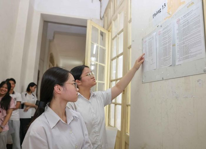 Thí sinh xem số báo danh của mình được niêm yết trước cửa phòng thi, điểm thi Trường THPT Trần Phú - Hoàn Kiếm (phường Cửa Nam). Ảnh: Thanh Tùng - TTXVN