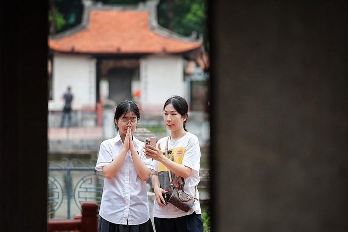 Nữ sinh thành kính trước khu bia Tiến sĩ, gửi gắm mong muốn học hành thuận lợi, thi cử suôn sẻ. Ảnh: Phạm Tuấn Anh - TTXVN