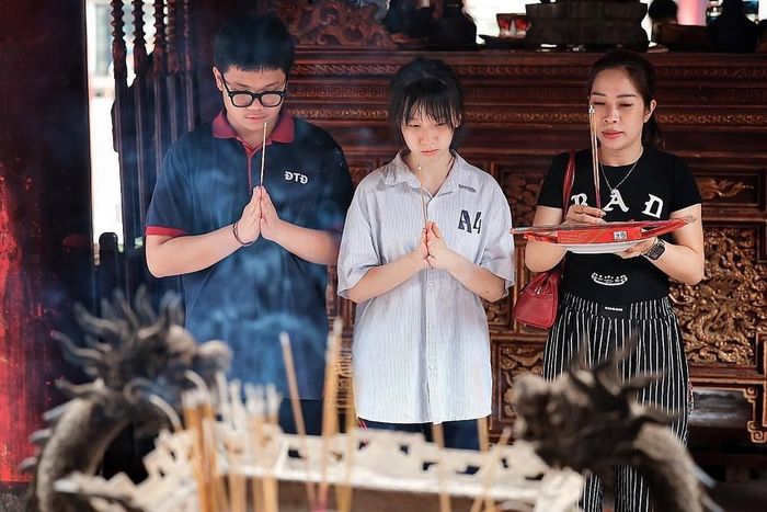 Học sinh và phụ huynh dâng hương trong không gian trầm mặc của Văn Miếu – Quốc Tử Giám. Ảnh: Phạm Tuấn Anh - TTXVN