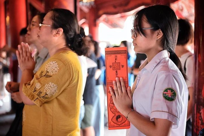 Nữ sinh thành kính cầu may trước kỳ thi quan trọng sắp tới. Ảnh: Phạm Tuấn Anh - TTXVN