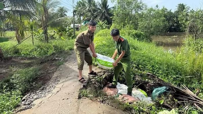 Công an xã Nhơn Mỹ gia cố đoạn kênh bị sạt lở.