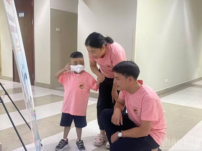 Hoàng Phúc Ng. cùng bố mẹ tại buổi lễ kỷ niệm thành tựu.