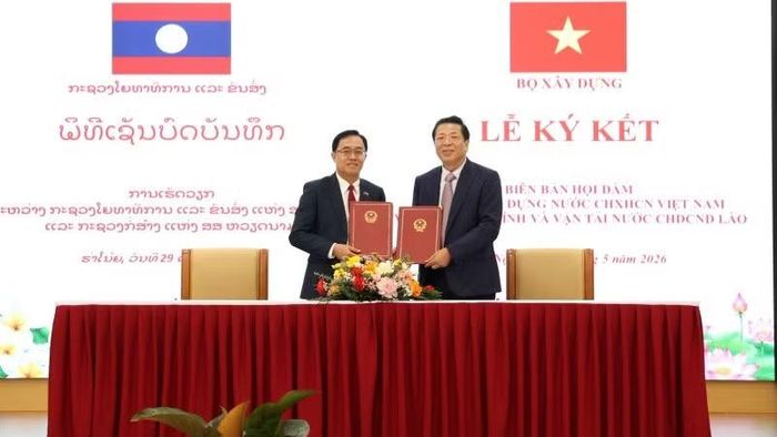 Bộ trưởng Trần Hồng Minh và Bộ trưởng Leklay Sivilay ký kết Biên bản làm việc giữa Bộ Xây dựng Việt Nam và Bộ Công chính và vận tải Lào. (Ảnh: Cổng thông tin Bộ Xây dựng)