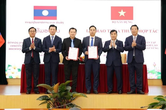 Bộ trưởng Trần Hồng Minh và Bộ trưởng Leklay Sivilay chứng kiến doanh nghiệp 2 nước trao Văn kiện hợp tác.