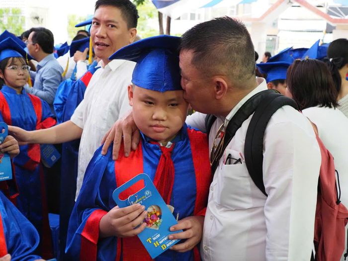  Một phụ huynh đặt lên trán con nụ hôn của sự tự hào và tình yêu thương vô bờ bến 