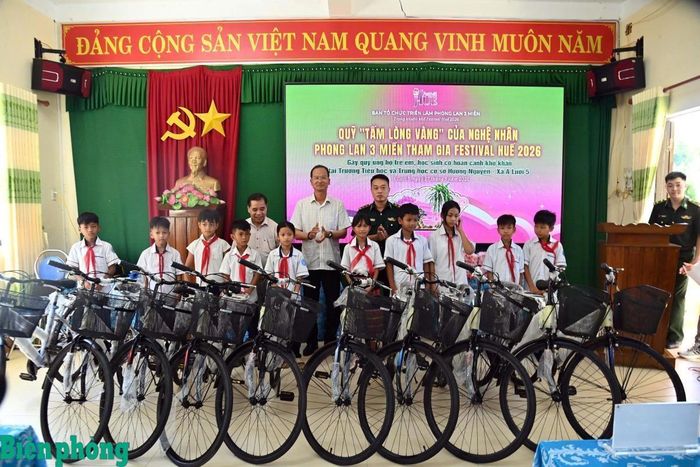 Cán bộ Đồn Biên phòng Hương Nguyên, Bộ đội Biên phòng thành phố Huế trao tặng xe đạp cho các học sinh hoàn cảnh khó khăn tại Trường Tiểu học và Trung học cơ sở Hương Nguyên, thành phố Huế. Ảnh: Võ Tiến