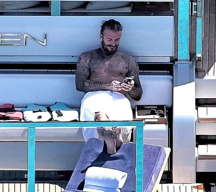 Beckham thoải mái tận hưởng kỳ nghỉ cùng gia đình, thỉnh thoảng tương tác ống kính máy ảnh của paparazzi, theo Daily Mail.