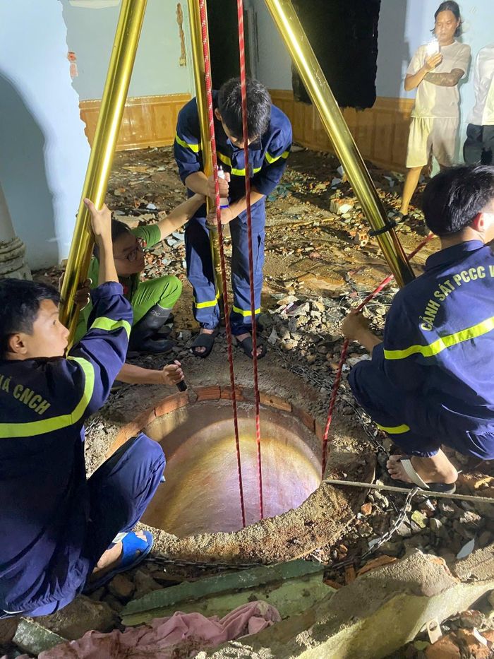 Lực lượng chức năng cứu thành công người phụ nữ nhặt phế liệu rơi xuống giếng nước sâu. (Ảnh: CA H.P).