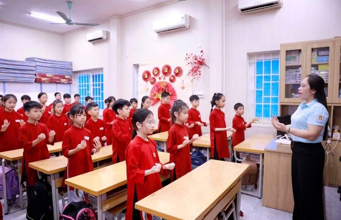 Tiết học truyền dạy hát Xoan tại Trường Tiểu học Gia Cẩm phường Việt Trì, nơi các học sinh trong trang phục áo dài truyền thống chăm chú thực hành theo hướng dẫn của giáo viên âm nhạc. (Ảnh: Hoàng Hùng/TTXVN)