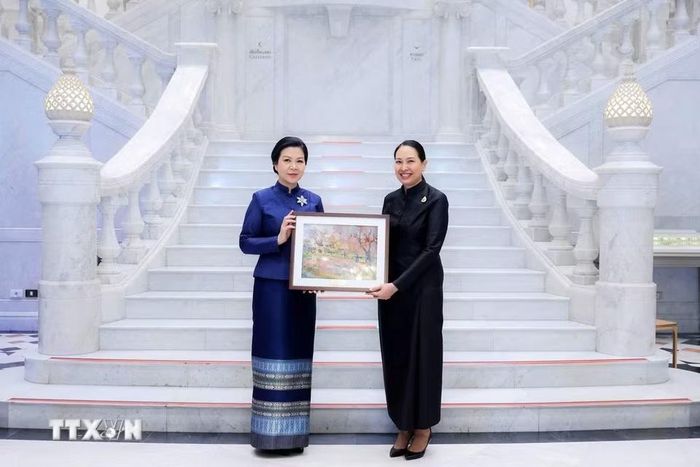 Phu nhân Ngô Phương Ly tặng một bức tranh phong cảnh Việt Nam cho Bảo tàng Dệt may Hoàng Thái hậu Sirikit. (Ảnh: TTXVN phát)