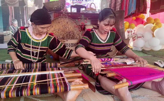 Bà Thị Y Rơ (76 tuổi, người dân tộc M’nông) truyền dạy nghề dệt thổ cẩm cho con dâu là chị Thị Tức. (Ảnh: K GƯỈH/TTXVN)