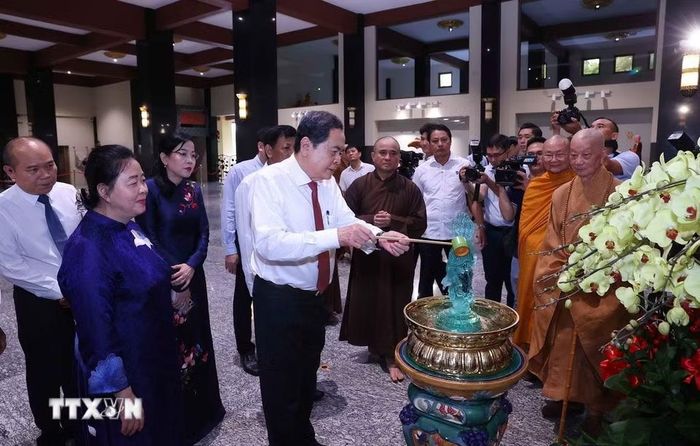 Chủ tịch Quốc hội Trần Thanh Mẫn thực hiện nghi lễ tắm Phật. (Ảnh: Văn Điệp/TTXVN)