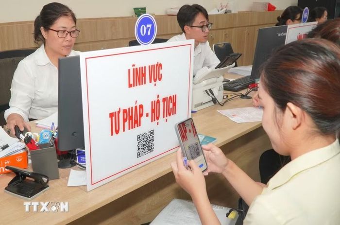 Người dân quét mã QR để tra cứu thủ tục và quy trình hồ sơ thuộc lĩnh vực tư pháp - hộ tịch. (Ảnh: Hữu Duyên/TTXVN)