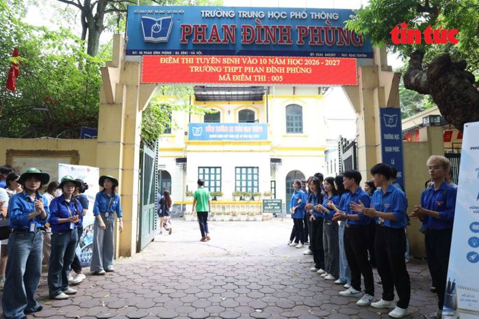Đội hình đoàn viên, thanh niên túc trực tại cổng trường để hướng dẫn, hỗ trợ thí sinh và phụ huynh.