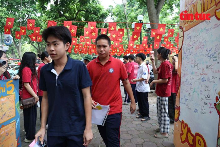 Các học sinh, tình nguyện viên cùng chụp ảnh lưu niệm bên bảng cổ vũ “Hôm nay tớ đi thi”...¹
