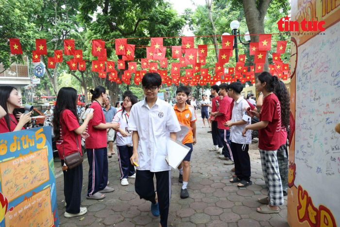 Thí sinh rời khu vực cổng trường sau khi hoàn tất thủ tục, bên cạnh các bảng lưu niệm ghi lời chúc của bạn bè.