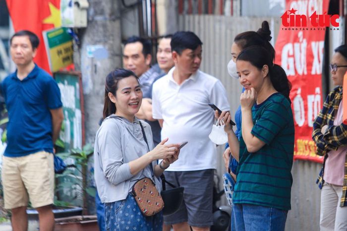 Phụ huynh đứng đợi con làm thủ tục bên ngoài điểm thi Trường Trung học phổ thông Yên Hòa.