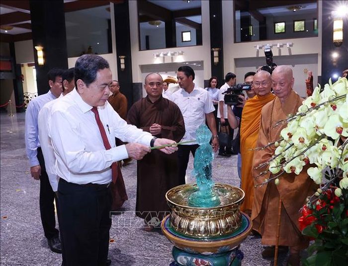 Chủ tịch Quốc hội Trần Thanh Mẫn thực hiện nghi lễ tắm Phật. Ảnh: Văn Điệp/TTXVN