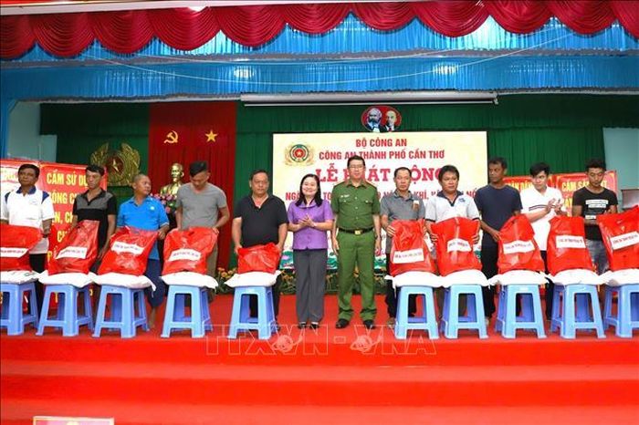 Ban tổ chức tặng quà cho người dân tự nguyện giao nộp vũ khí, công cụ hỗ trợ, thiết bị xung điện tại Lễ phát động. Ảnh: TTXVN phát