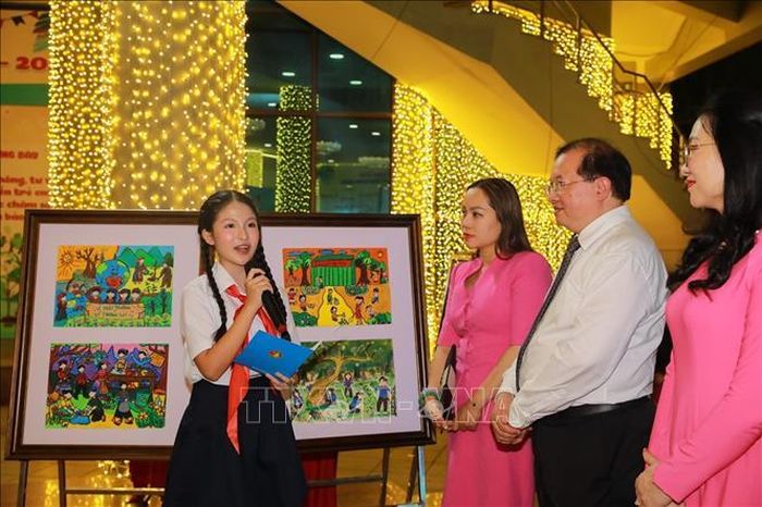 Các đại biểu nghe thuyết trình về triển lãm tranh thiếu nhi ứng phó với biến đổi khí hậu. Ảnh: Khánh Hòa/TTXVN