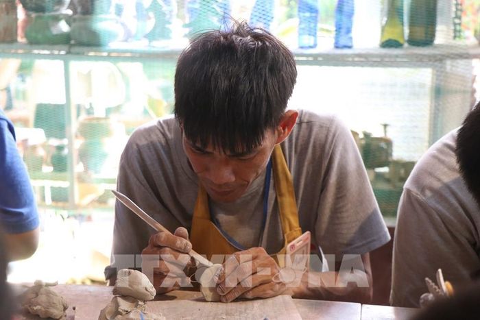 Học viên khuyết tật học làm gốm tại Trung tâm Hy vọng Huế. Ảnh: Mai Trang - TTXVN