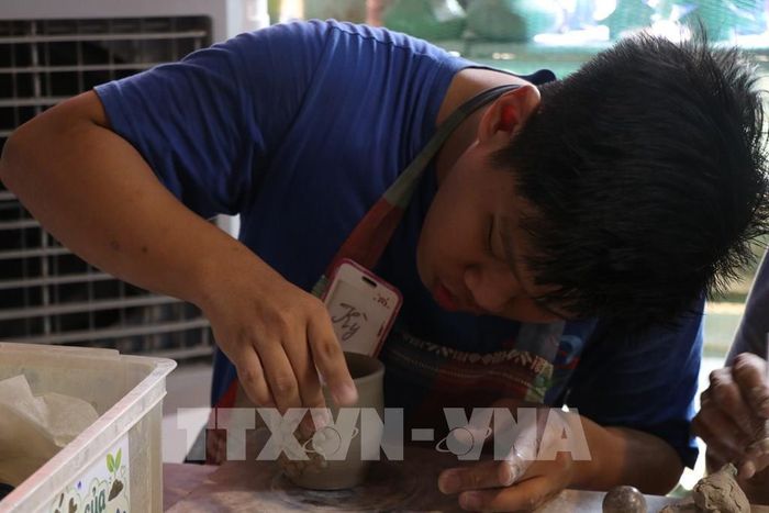 Học viên Trung tâm Hy vọng Huế học làm gốm. Ảnh: Mai Trang - TTXVN