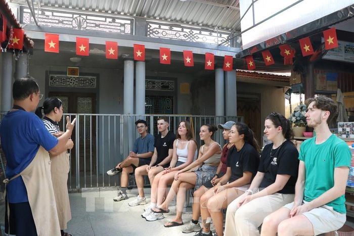 Du khách nước ngoài học ngôn ngữ ký hiệu trước khi trải nghiệm tại Trung tâm Hy vọng Huế. Ảnh: Mai Trang - TTXVN