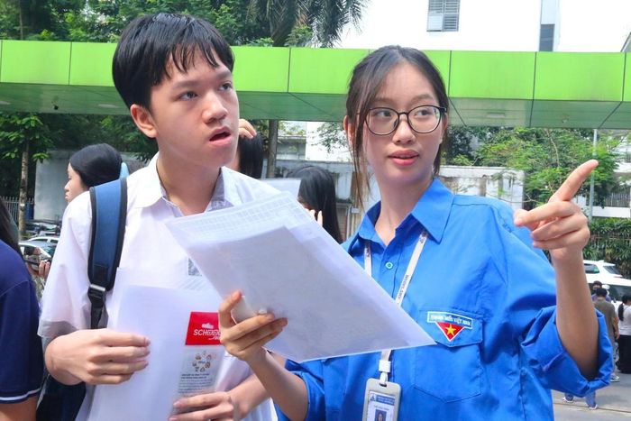 Lực lượng thanh niên tình nguyện hỗ trợ thí sinh đến làm thủ tục tại điểm thi Trường THCS Trần Duy Hưng.
