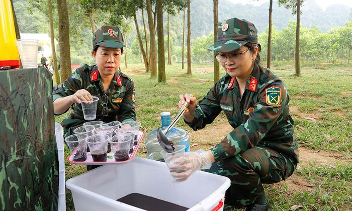 Hội viên phụ nữ chuẩn bị nước chè đỗ đen phục vụ chiến sĩ mới tại thao trường.