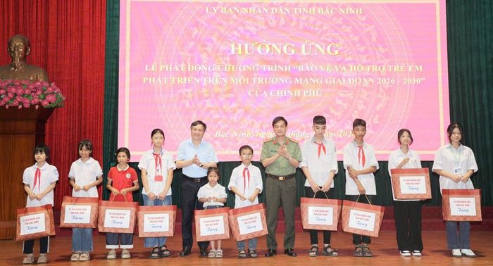  Các đại biểu trao quà cho học sinh có hoàn cảnh khó khăn tại lễ phát động. 