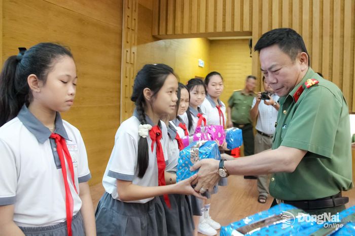 Đại tá Nguyễn Phương Đằng, Phó Giám đốc Công an thành phố Đồng Nai tặng quà cho các em học sinh tại buổi lễ. Ảnh: Trần Danh